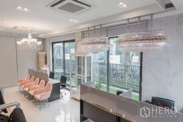 Home Office for sale in Don Mueang, Bangkok - Open office area with pink visitor chairs, crystal chandeliers and floor-to-ceiling windows to a small garden.