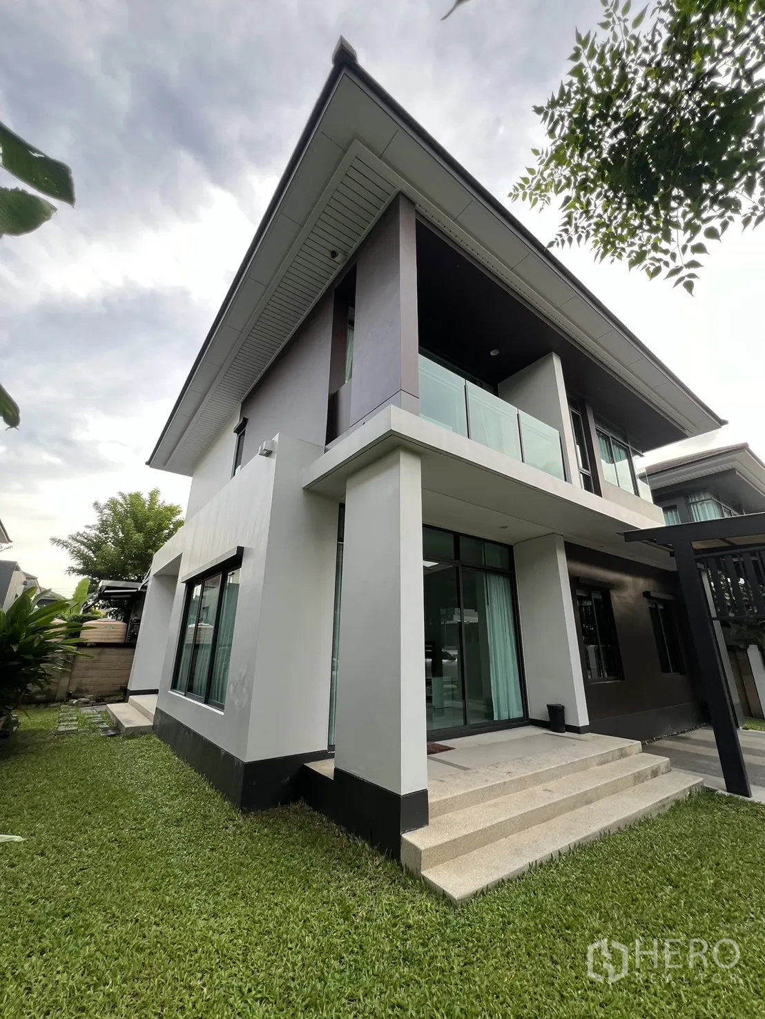 บ้าน ให้เช่าในBang Kapi, Bangkok - มุมอาคารแสดงระเบียง หน้าต่างบานใหญ่ และสนามหญ้า