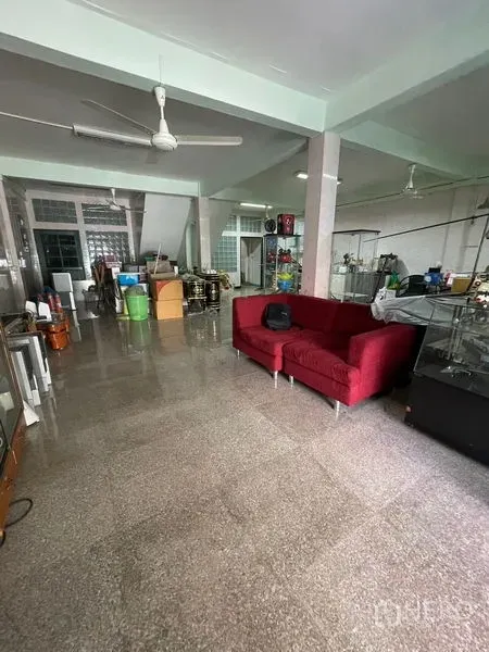 Shophouse for sale in Sathon, Bangkok - Open-plan ground floor with terrazzo flooring, ceiling fans and a red sofa, ideal for showroom space.