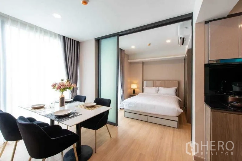 Condominium for rent in Huai Khwang, Bangkok - Dining space connected to the bedroom via glass sliding partitions.