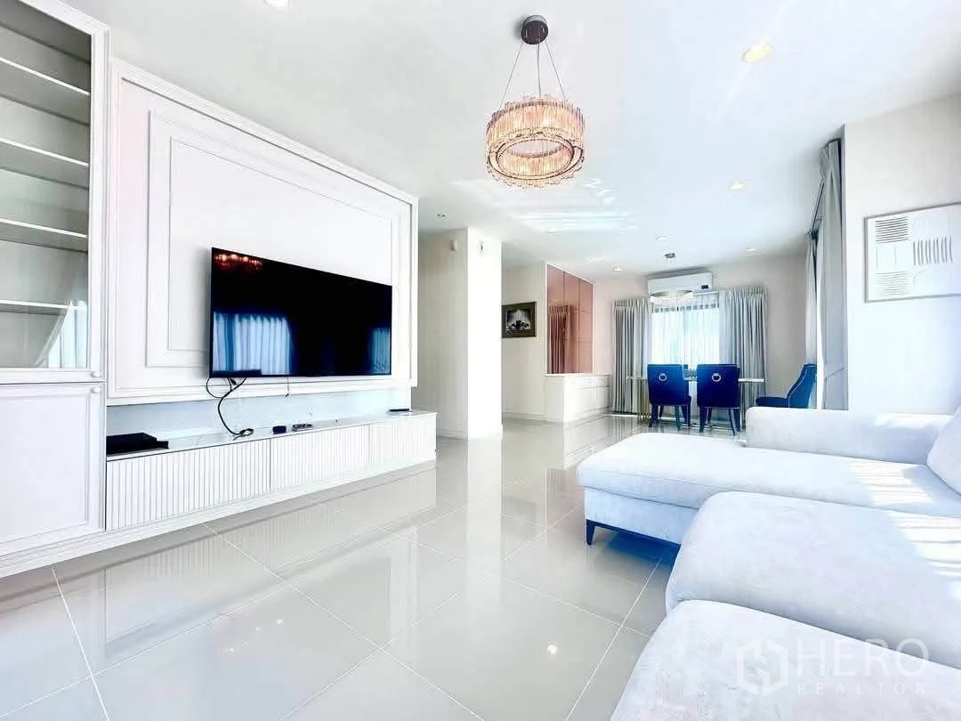 Detached House for rent in Bang Kapi, Bangkok - Open-plan living and dining area with chandelier and glossy floor tiles.