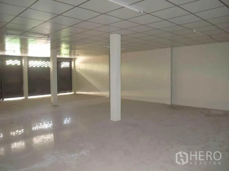 Warehouse for rent in Wang Thonglang, Bangkok - Open-plan warehouse interior with columns, tiled ceiling and concrete floor for storage or light industry.