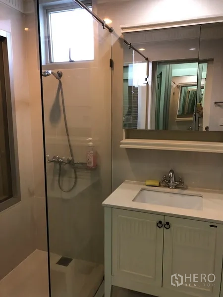 คอนโด ให้เช่าในPathum Wan, Bangkok - ห้องน้ำสมัยใหม่พร้อมฉากกั้นอาบน้ำกระจก อ่างล้างหน้า และตู้กระจก