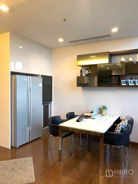 Condominium for rent or sale in Huai Khwang, Bangkok - Dining corner with a four-seat table, open shelving, and modern refrigerator.