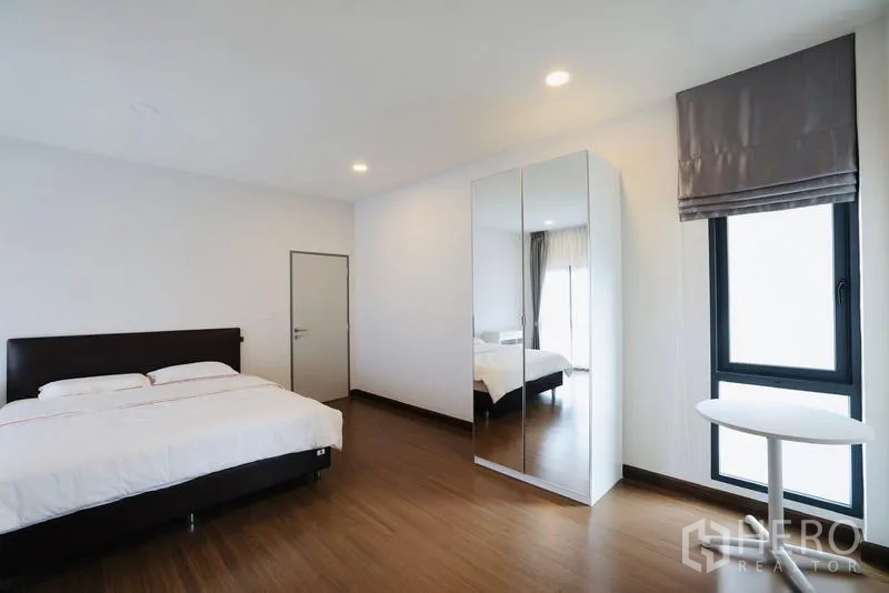 Detached House for rent in Bang Phli, Samut Prakan - Minimalist bedroom with double bed, mirrored wardrobe, and small side table.