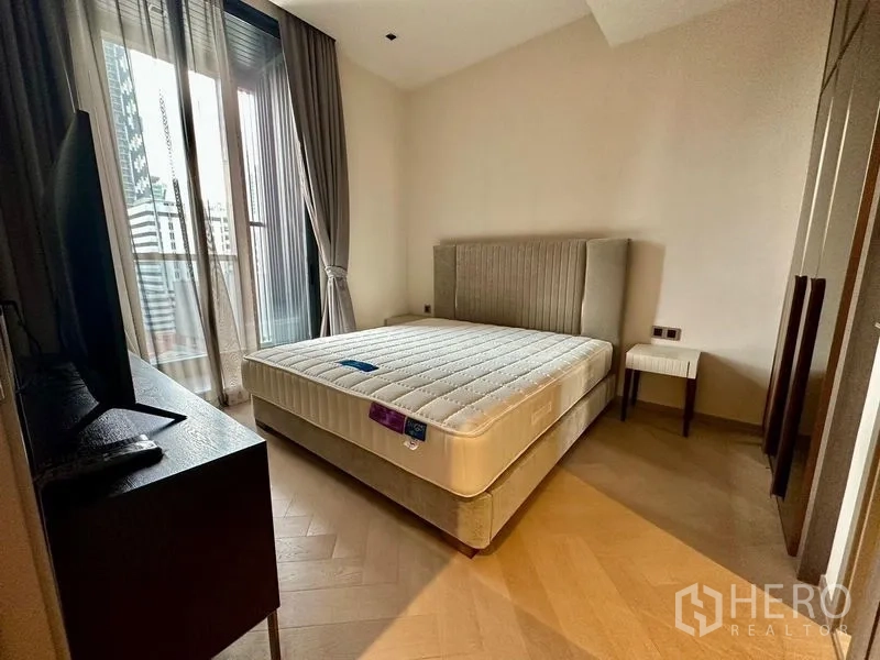 Condominium for rent - Cozy bedroom with upholstered headboard, large window, balcony access and a TV cabinet.