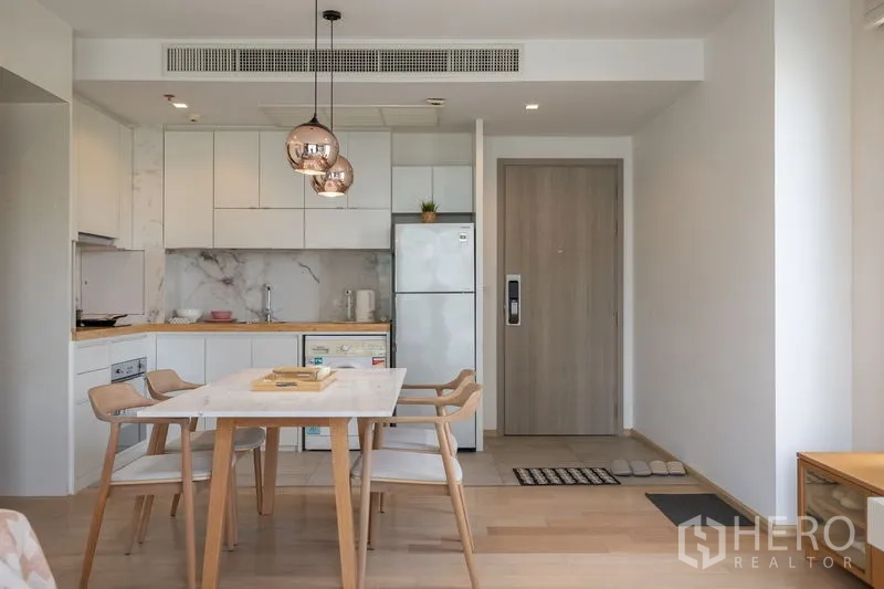 Condominium for rent in Watthana, Bangkok - Spacious open-plan room linking living area, dining and marble-backdrop kitchen.