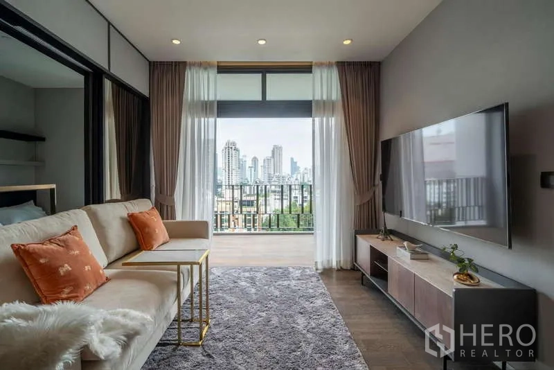 คอนโด ให้เช่าหรือขายในWatthana, Bangkok - ห้องนั่งเล่นสว่างพร้อมระเบียงและวิวสกายไลน์ที่ MUNIQ สุขุมวิท 23