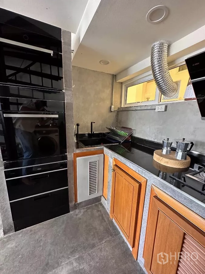 คอนโด ให้เช่าในWatthana, Bangkok - ครัวขนาดกะทัดรัด เคาน์เตอร์หินสีดำ ตู้ไม้ และหน้าต่างระบายอากาศ