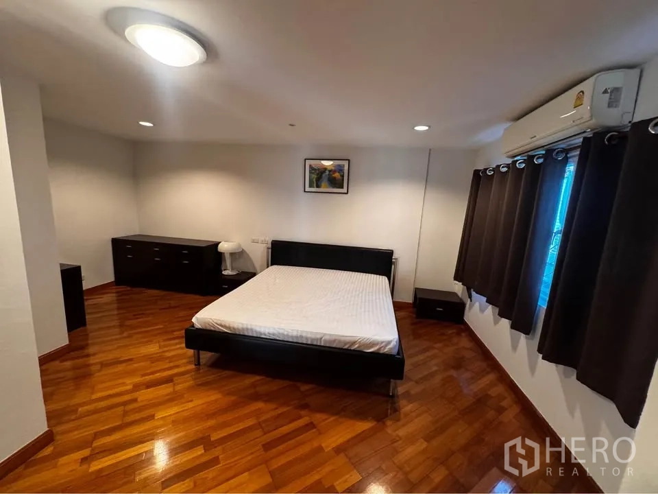 ทาวน์เฮาส์ for rent in Huai Khwang, Bangkok - ห้องนอนพื้นไม้ เตียงนอน ผ้าม่านทึบ และเครื่องปรับอากาศ.