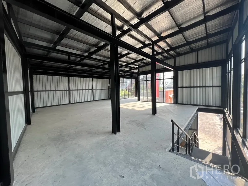 零售空间 出租在Bang Na, Bangkok - 二层零售区，外露钢梁与楼梯井俯瞰入口。