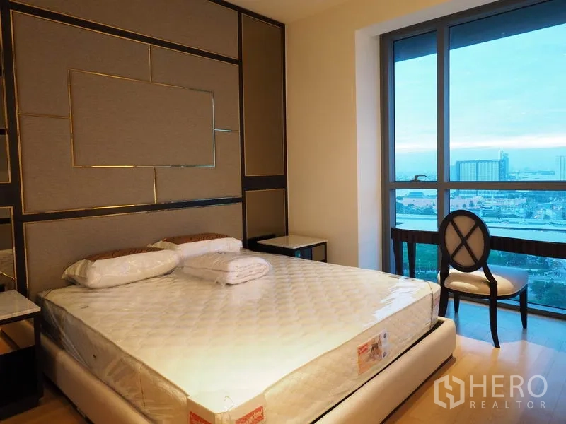 Condominium for rent in Yan Nawa, Bangkok - Bedroom with floor-to-ceiling window capturing river and skyline panorama.