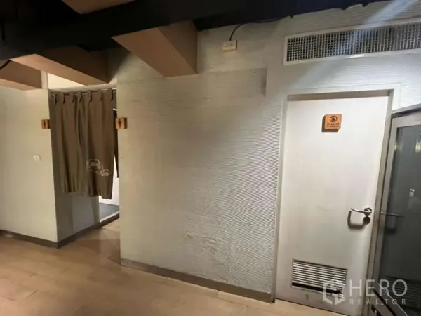 店屋 出租或出售在Khlong Toei, Bangkok - 室内走廊，木地板与纹理墙面，通往服务用房的门。