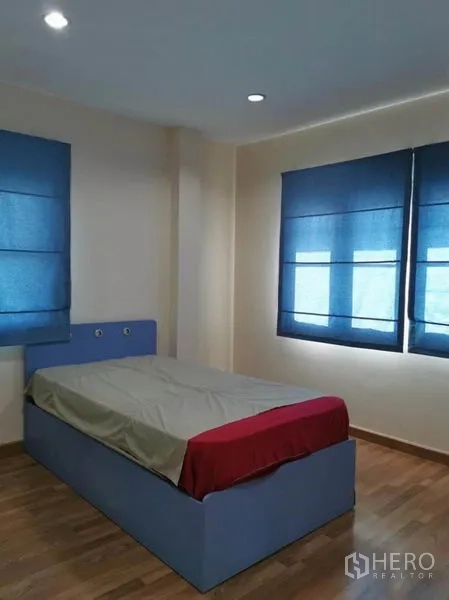 Detached House for rent in Bang Kapi, Bangkok - Single bedroom with blue blinds, corner windows and wood floors for ample daylight.