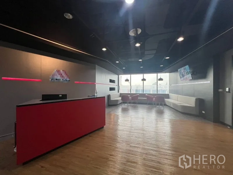 办公空间 出租在Huai Khwang, Bangkok - 现代接待大厅，红色前台、木地板与城市景观。