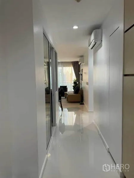 Condominium for rent or sale in Watthana, Bangkok - Clean hallway facing the living room with air conditioning and glossy floors.