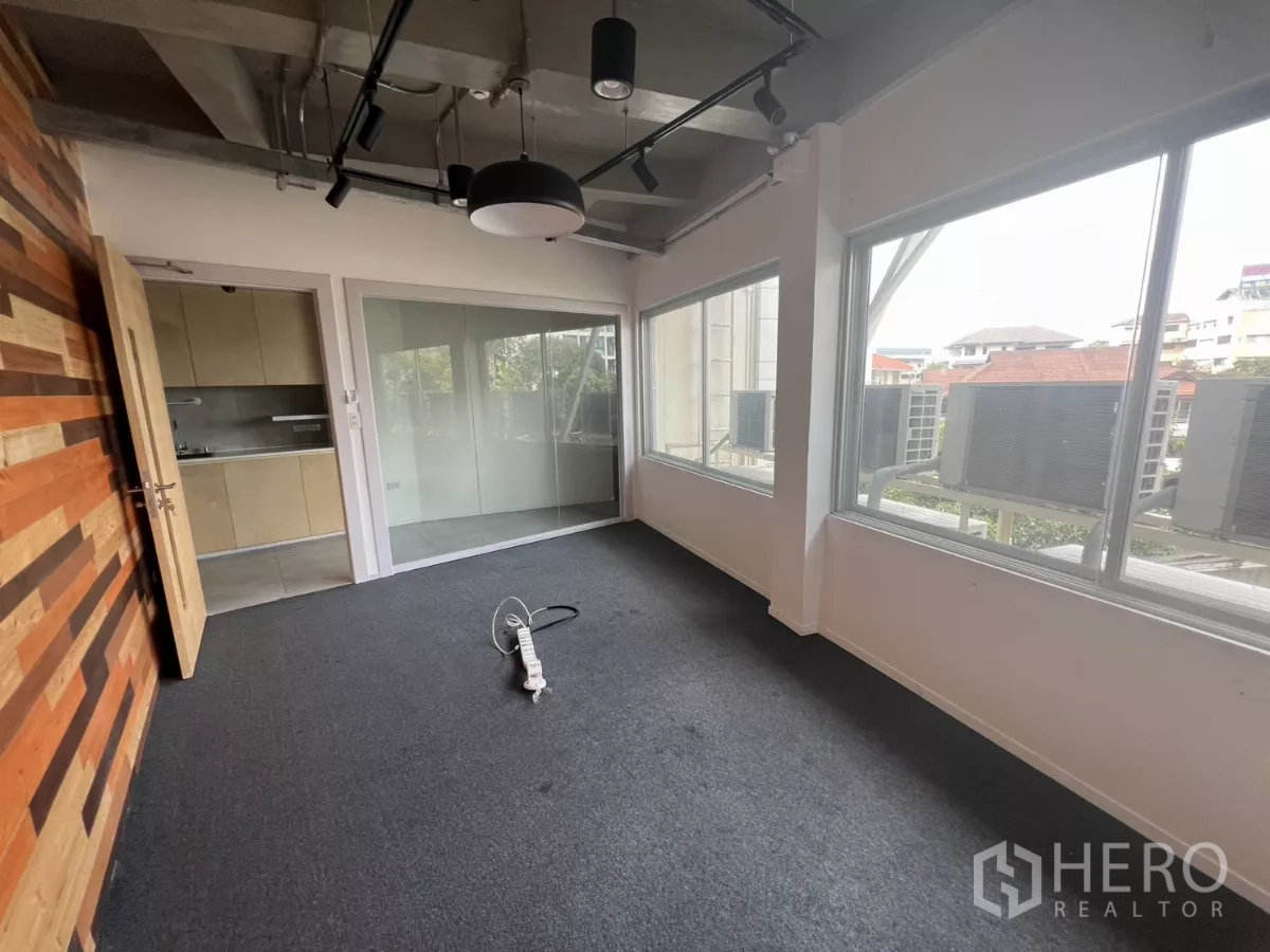 零售空间 出租在Khlong Toei, Bangkok - 采光充足的办公室，大窗户望向空调外机与绿树。