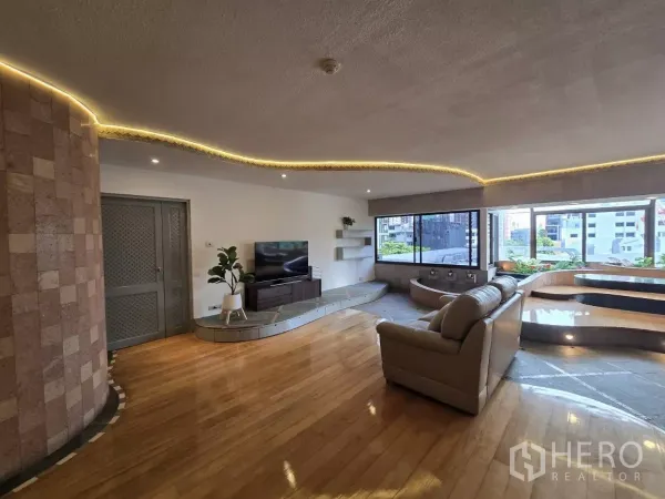 公寓 出租在Pathum Wan, Bangkok - 宽敞客厅，皮沙发、电视柜、灯带与落地窗