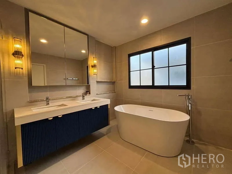 Detached House for rent in Bang Phli, Samut Prakan - Modern bathroom featuring freestanding bathtub, double vanity and frosted window.