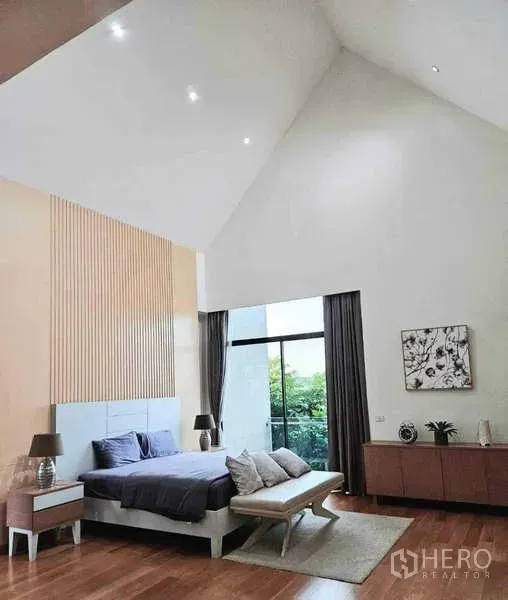 บ้าน ขายในKhlong Sam Wa, Bangkok - ห้องนอนเพดานจั่วสูง ผนังกระจกเต็มบาน พร้อมระเบียงมองเห็นพื้นที่สีเขียว