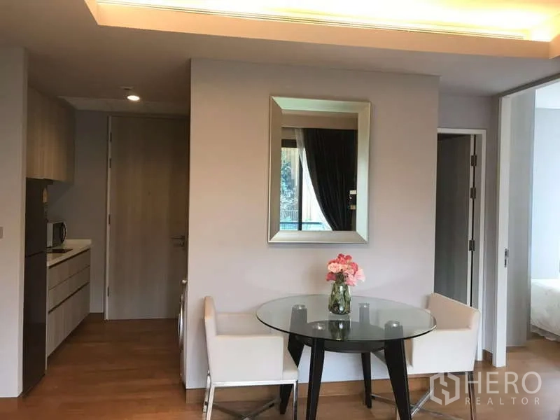 คอนโด ให้เช่าในKhlong Toei, Bangkok - มุมรับประทานอาหารโต๊ะกระจก เก้าอี้สองตัว กระจกเงาบนผนัง ใกล้ทางเข้าห้องนอน