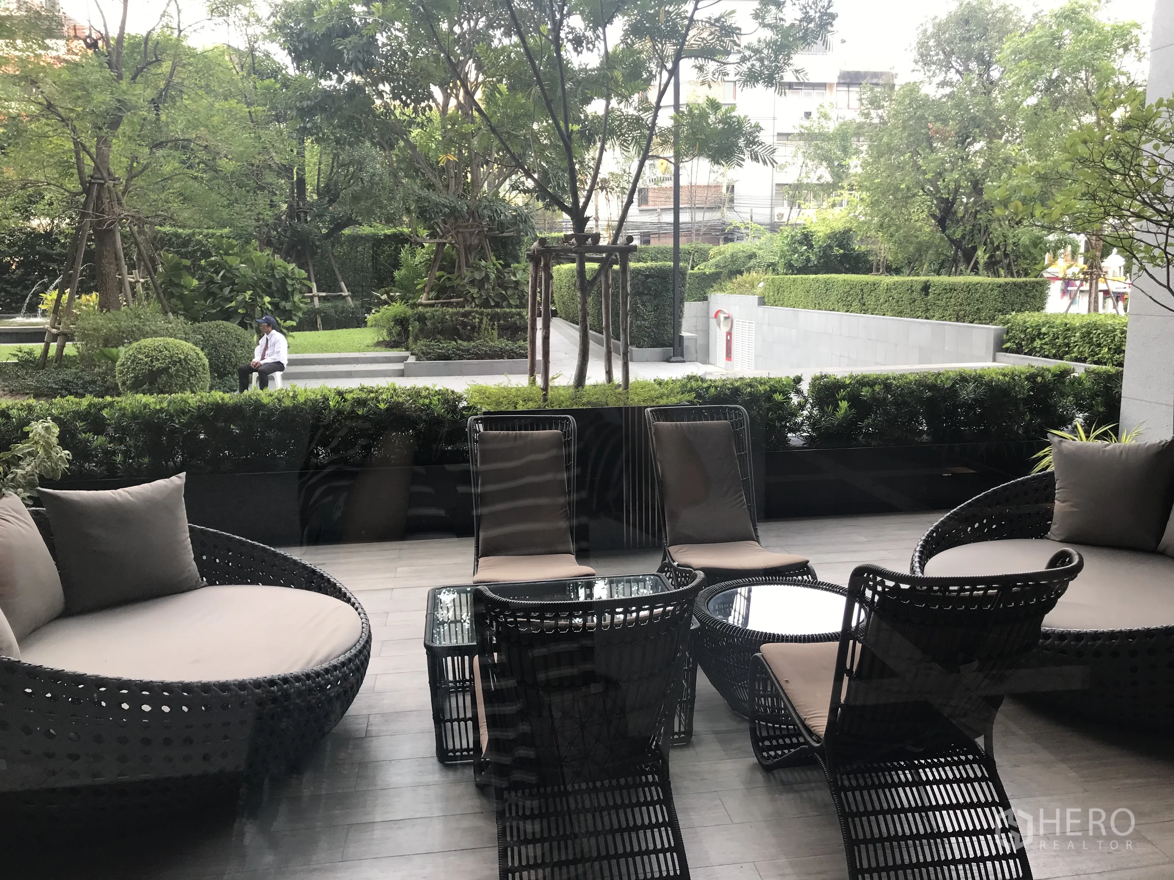 Condominium for sale in Khlong Toei, Bangkok - Landscaped garden terrace with woven lounge chairs and coffee tables.