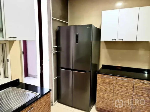 อพาร์ทเมนท์ ให้เช่า - ครัวแยกพร้อมตู้เย็นสแตนเลสแบบประตูคู่และเคาน์เตอร์หินสีดำ