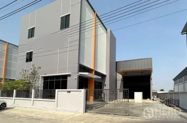 工厂 出租或出售在Lam Luk Ka, Pathum Thani - 三层办公楼与工厂正面，带大门与车道及装卸区。