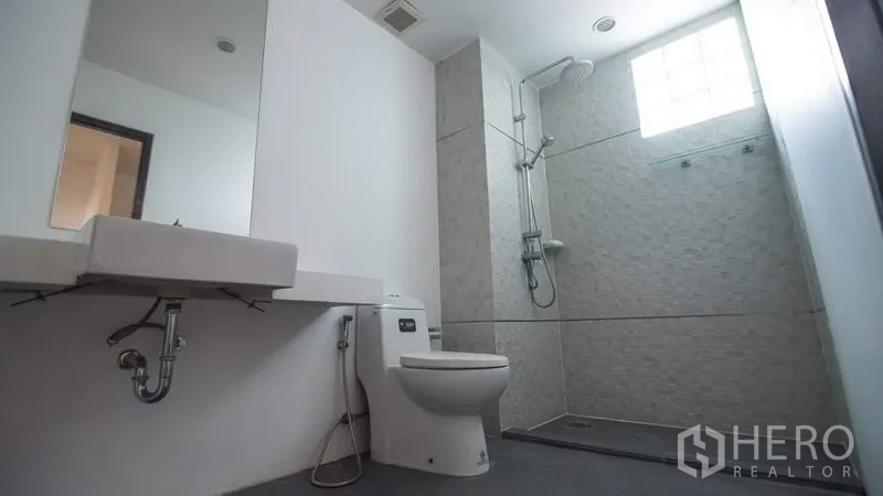 ทาวน์เฮาส์ ให้เช่าหรือขายในPhra Khanong, Bangkok - ห้องน้ำสว่าง มีอ่างล้างหน้าแบบแขวน โถสุขภัณฑ์ และโซนอาบน้ำแบบวอล์กอินพร้อมช่องแสงบล็อกแก้ว