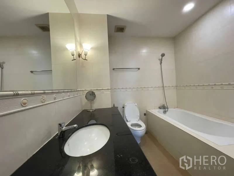 房间 出租在Khlong Toei, Bangkok - 浴室带长台面洗手盆、浴缸与墙面镜