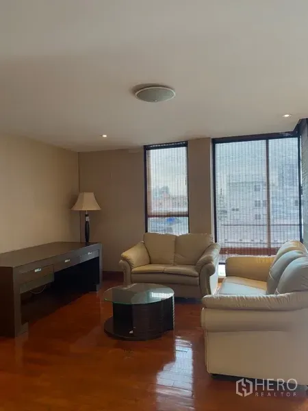 公寓 出租或出售在Watthana, Bangkok - 客厅设奶油色皮沙发、玻璃茶几、木地板与落地窗