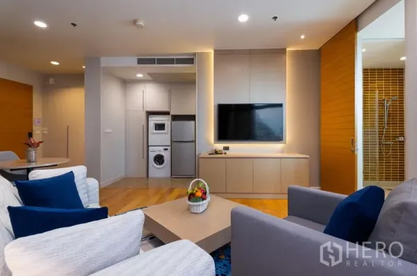 คอนโด ให้เช่าในBang Kho Laem, Bangkok - มุมนั่งเล่นอบอุ่นพร้อมโซฟา ทีวีติดผนัง พื้นไม้ มองเห็นพื้นที่ซักล้างและห้องน้ำ