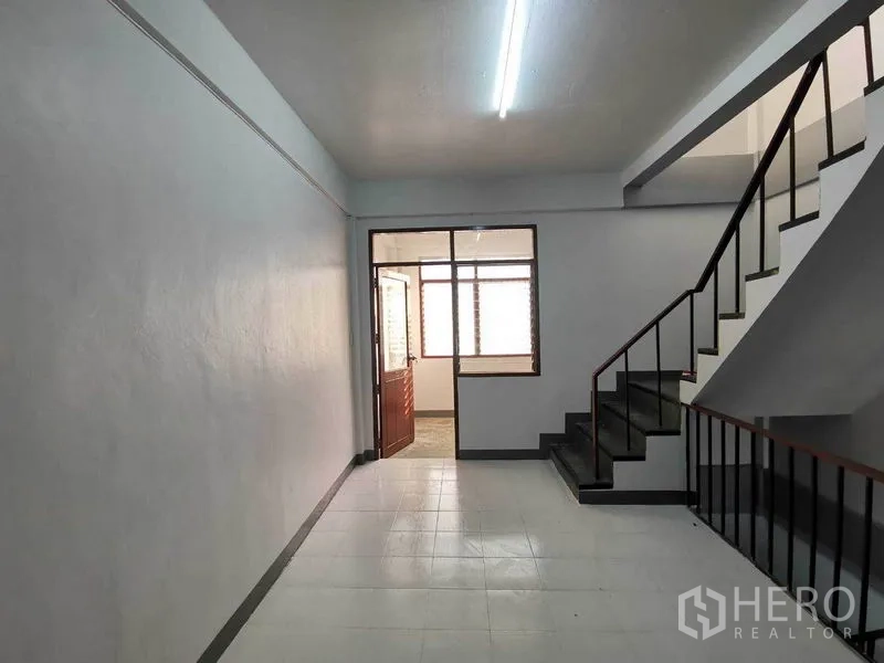 店屋 出租在Wang Thonglang, Bangkok - 走廊区通向玻璃门与窗户，瓷砖地面。