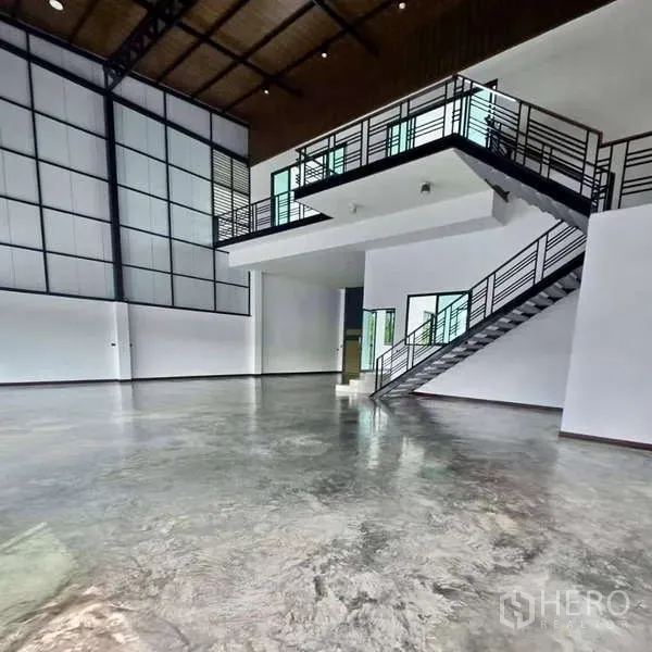 คลังสินค้า ขายในLam Luk Ka, Pathum Thani - ชั้นลอยออฟฟิศและบันไดเหล็กมองลงสู่พื้นที่โกดังเพดานสูง
