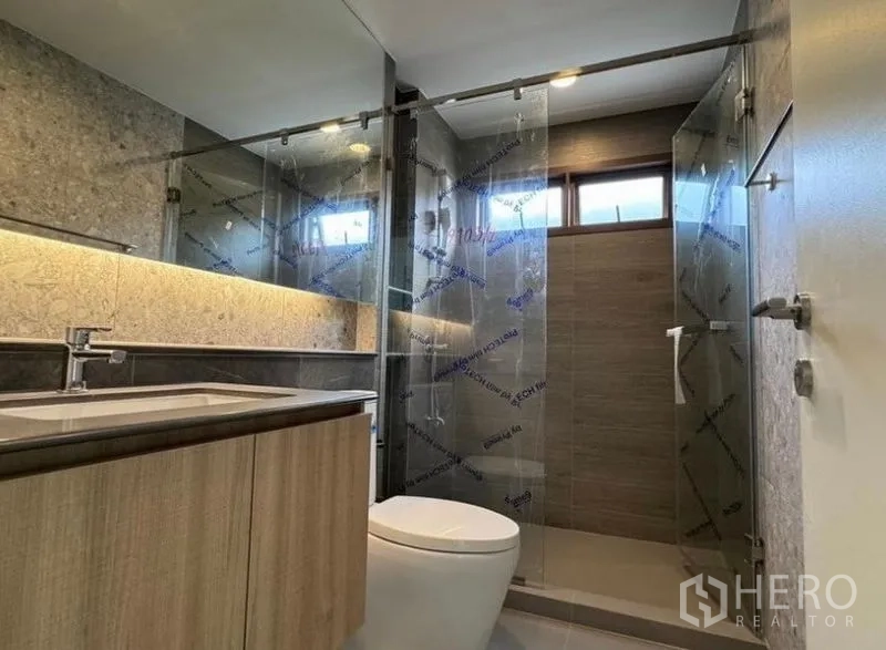 Detached House for rent in Bang Kapi, Bangkok - Modern bathroom with floating vanity and glass shower enclosure.