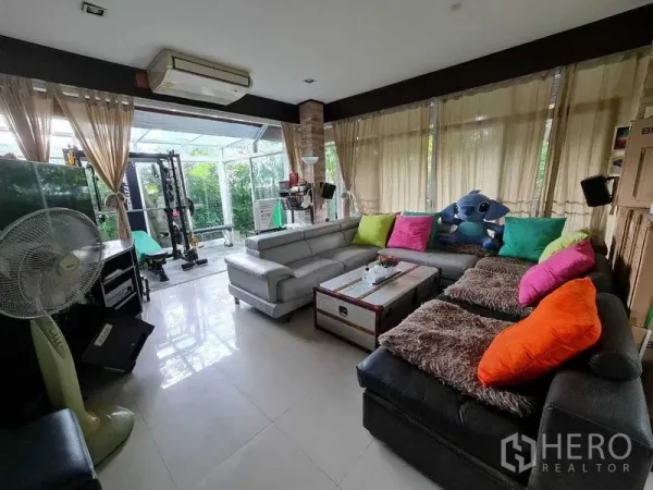 บ้าน ขายในBang Na, Bangkok - ห้องนั่งเล่นกว้าง โซฟาตัวแอล หน้าต่างบานใหญ่เปิดรับวิวสวน