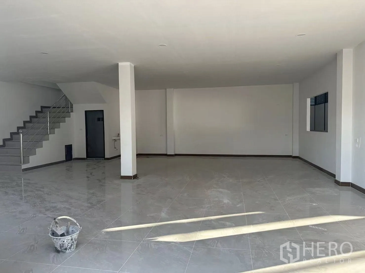 工厂 出租在Nong Khaem, Bangkok - 一层开放式办公室，带楼梯、亮面地砖及面向仓库的窗户。