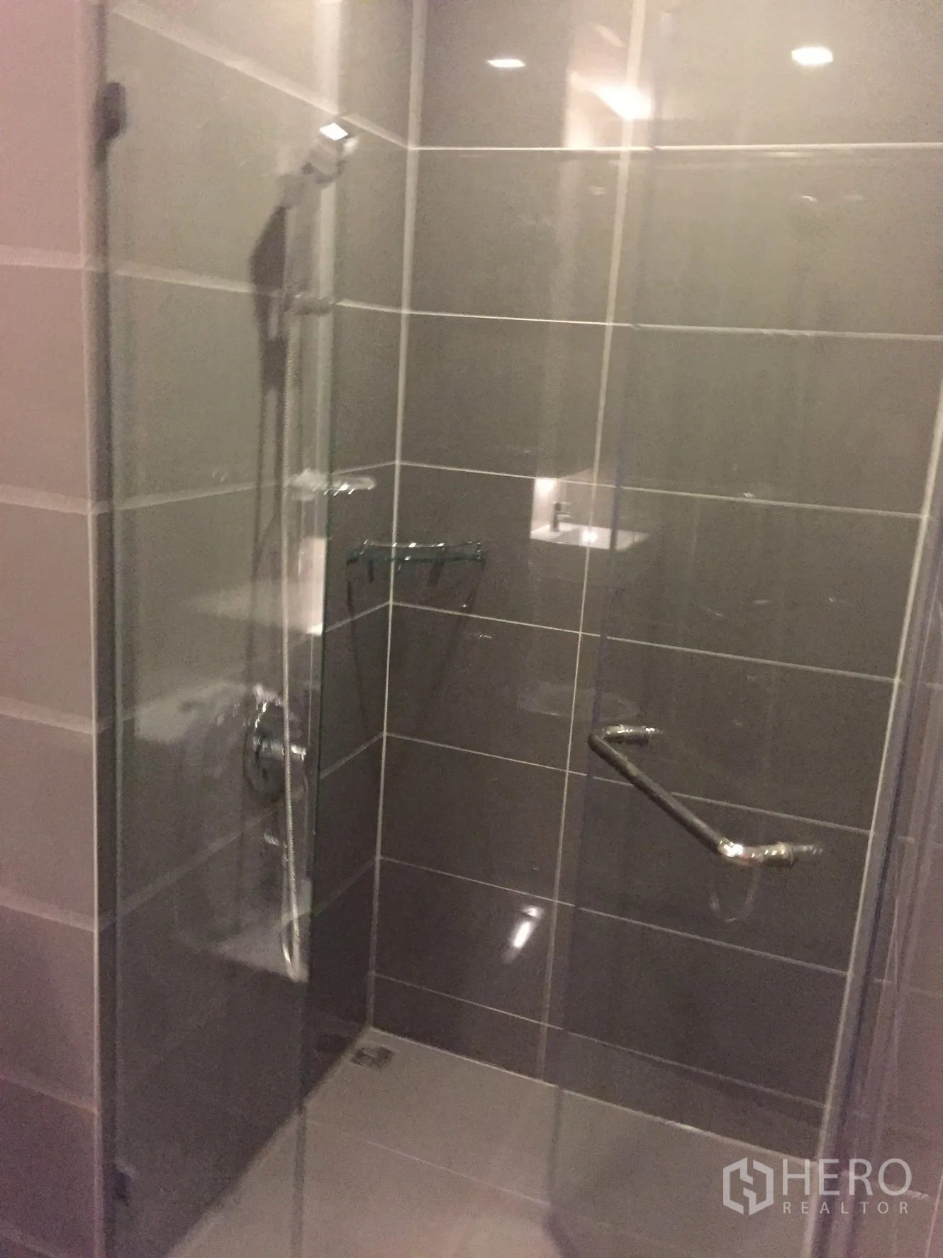 公寓 出租在Watthana, Bangkok - 现代浴室，灰色瓷砖墙面与玻璃淋浴间。