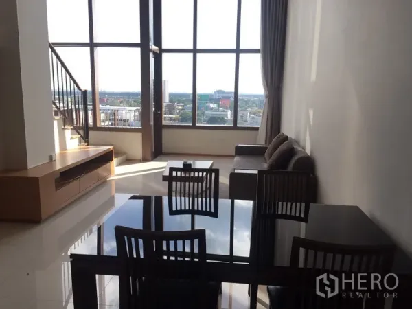 คอนโด ให้เช่าในKhlong Toei, Bangkok - ห้องนั่งเล่นและรับประทานอาหารเพดานสูง กระจกเต็มผนัง บันได และวิวเมือง