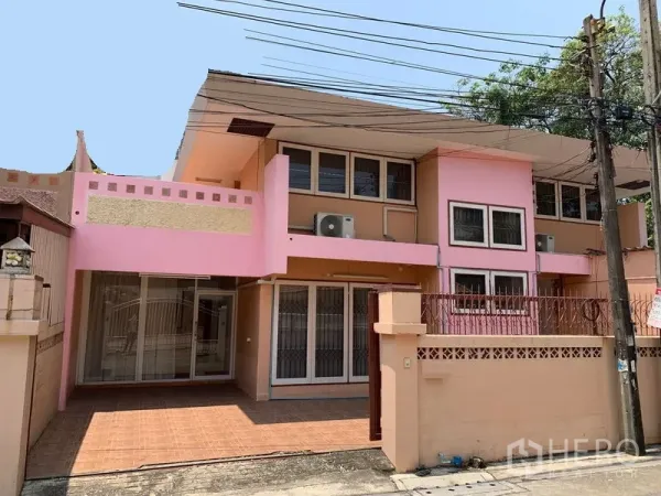 办公空间 出租在Chatuchak, Bangkok - 两层外立面粉色建筑，带前院围栏与可停车空间。