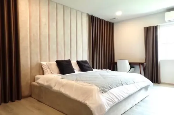 Detached House for rent in Bang Phli, Samut Prakan - Spacious master bedroom with padded headboard wall, king bed, desk and blackout curtains.