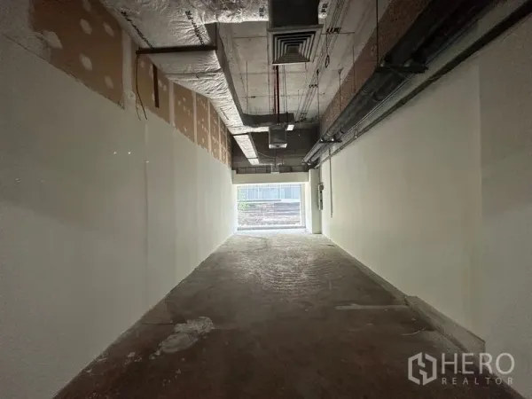 พื้นที่ขายปลีก ให้เช่าในWatthana, Bangkok - ภายในร้านค้ายังไม่ตกแต่ง เพดานเดินงานระบบ เปลือย ผนังสีขาว พื้นคอนกรีตและแสงธรรมชาติด้านหลัง.