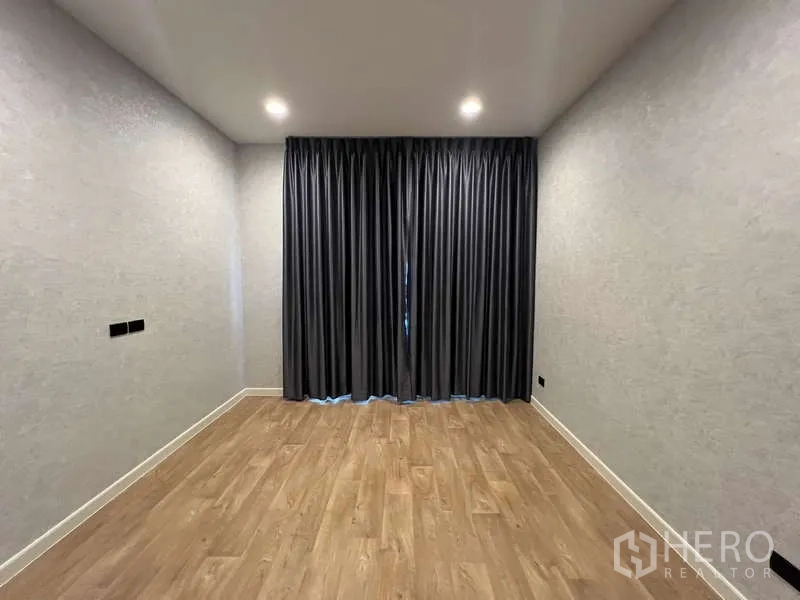 บ้าน ให้เช่าในBang Kapi, Bangkok - ห้องอเนกประสงค์โล่ง พื้นไม้และผ้าม่านสีเข้ม