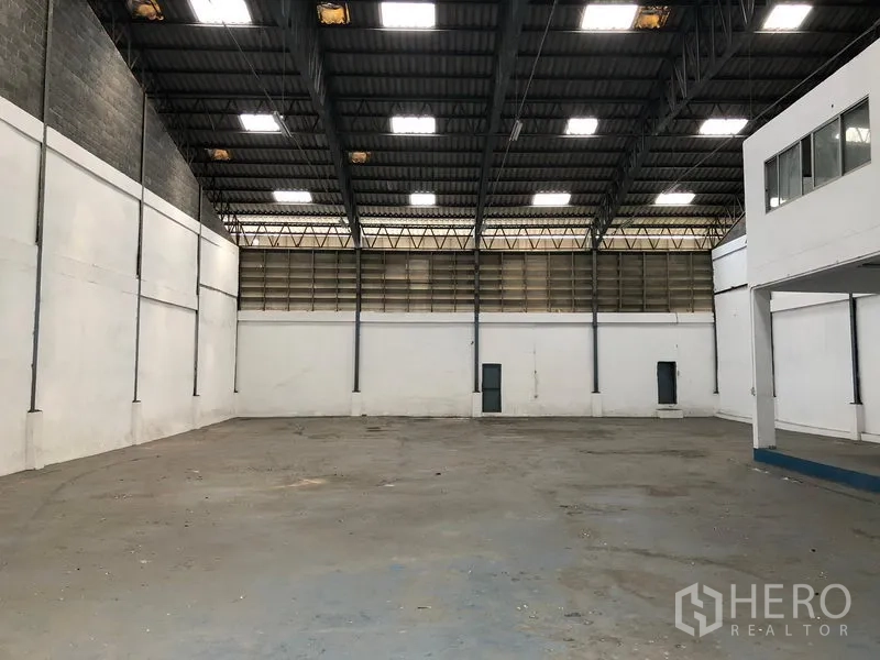 คลังสินค้า ให้เช่าในBang Phli, Samut Prakan - พื้นโกดังโล่ง โปร่งเพดานสูง แผ่นหลังคาโปร่งแสง และประตูทางเข้าออกด้านข้าง