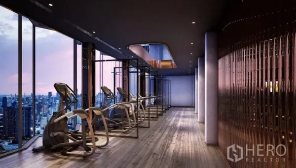 Condominium for sale in Ratchathewi, Bangkok - Sky gym with rows of cardio machines facing floor-to-ceiling city views at dusk.