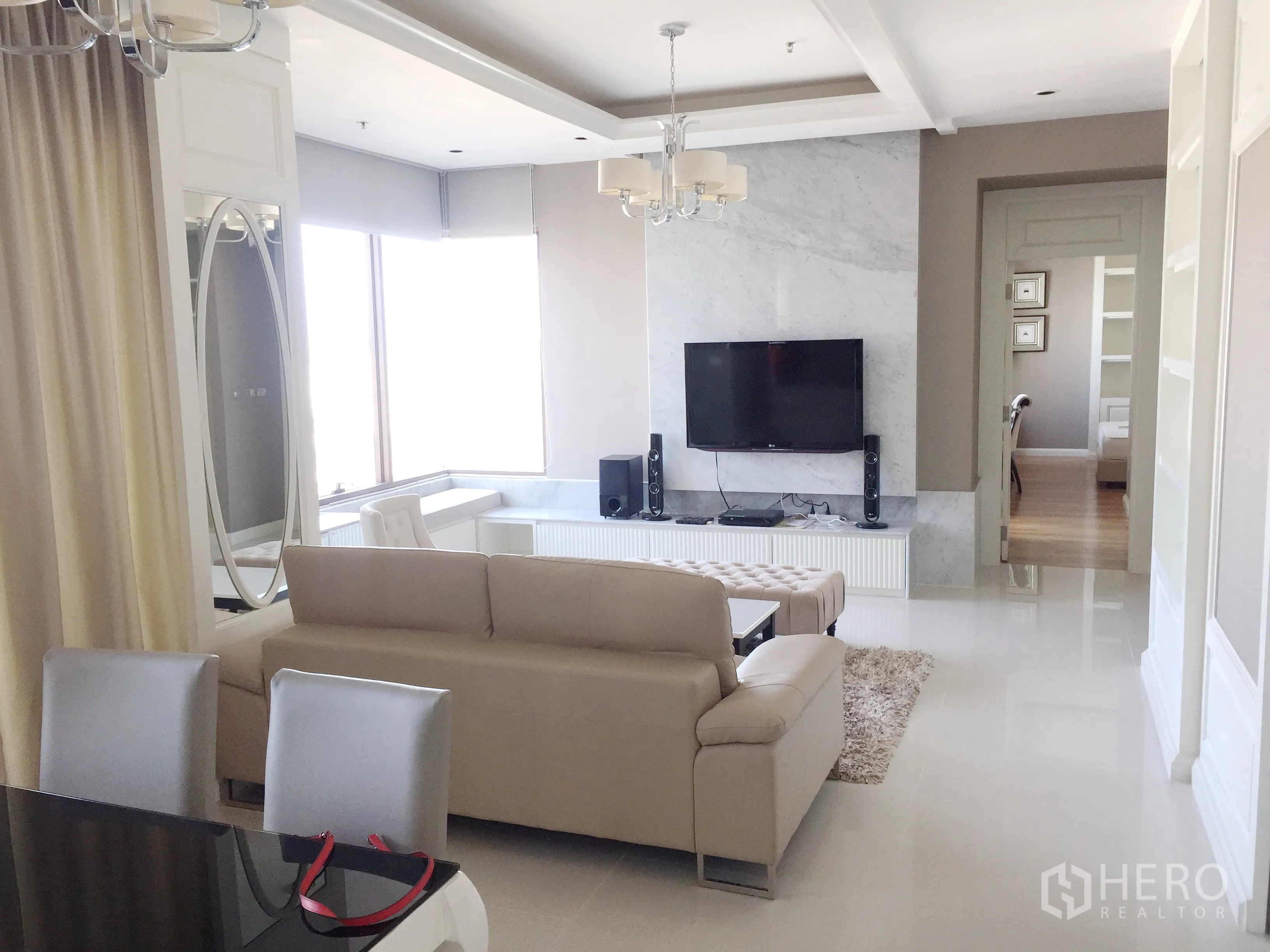 คอนโด ให้เช่าในKhlong Toei, Bangkok - ห้องนั่งเล่นและรับประทานอาหารสว่าง โซฟาสีเบจ ทีวีและผนังลายหินอ่อน