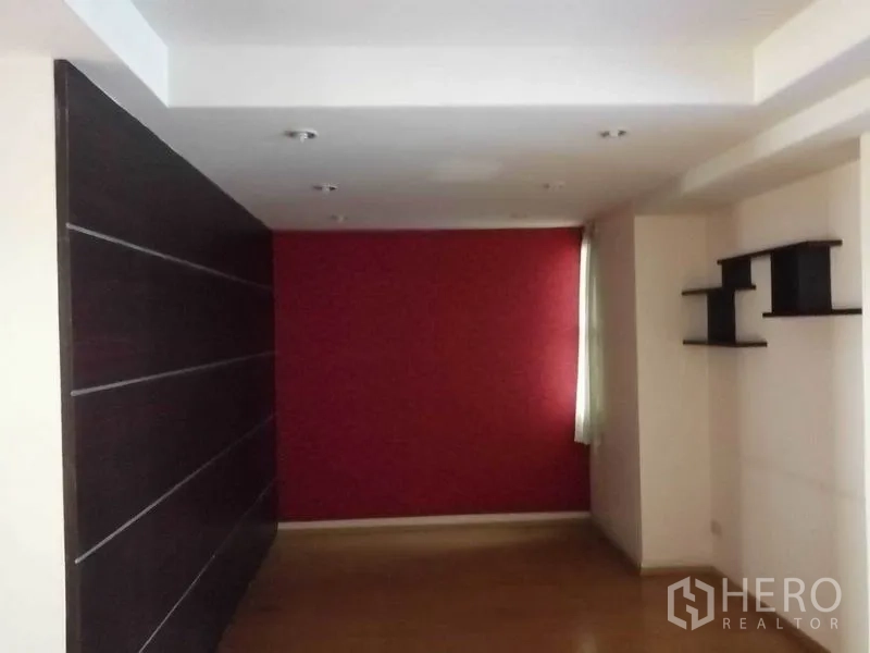 办公空间 出租在Khlong Toei, Bangkok - 紧凑工作间，红色强调墙、深色饰面与壁架。