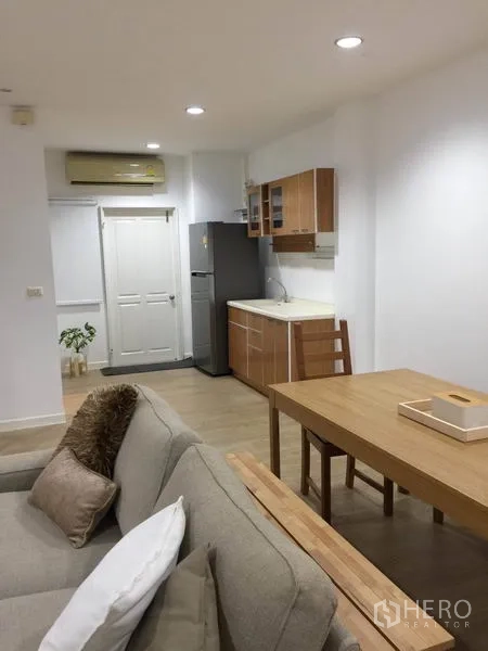 ทาวน์เฮาส์ ให้เช่าในLat Phrao, Bangkok - ครัวขนาดกะทัดรัดติดกับโซนรับแขก มีตู้เก็บของ โต๊ะไม้ และตู้เย็น