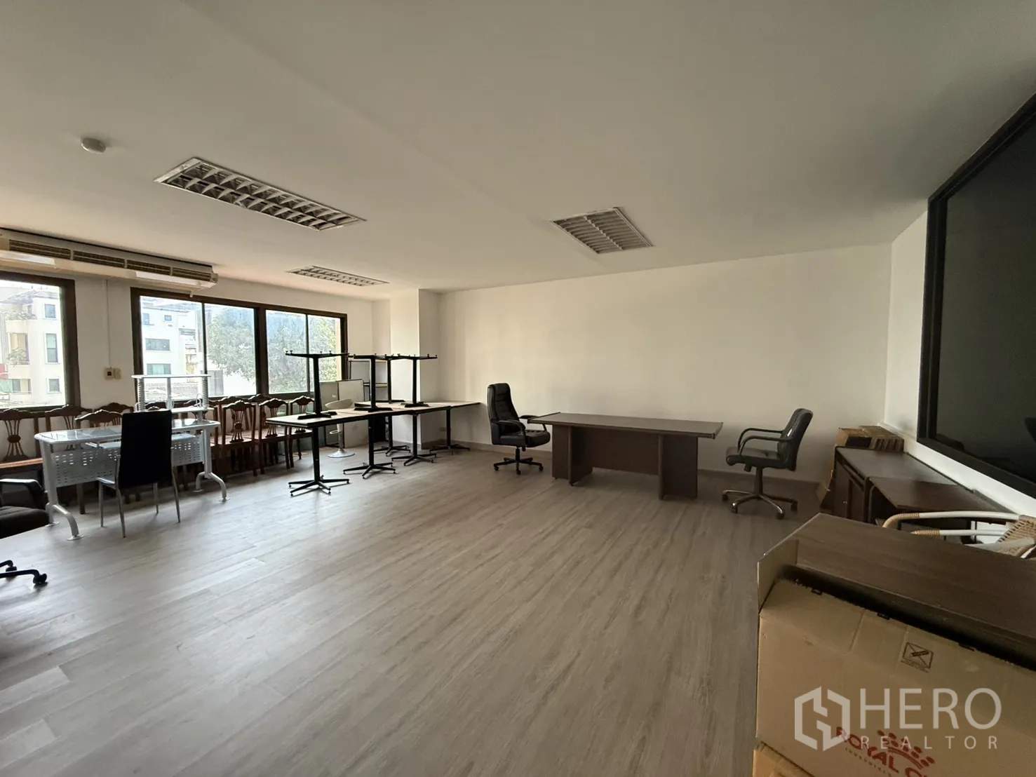 Office Space for rent in Sathon, Bangkok - Bright workspace featuring long desks, rolling chairs, wood floors, and a wide window line with city outlook.