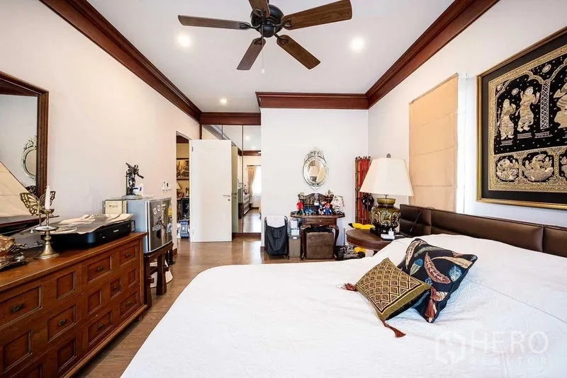 Detached House for sale in Prawet, Bangkok - Guest bedroom with ceiling fan and classic wooden furniture.